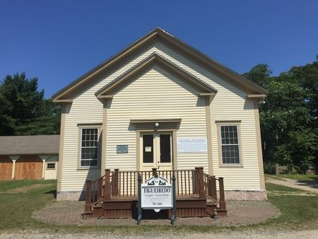 A small white building with a sign that says ' t.j. miller ' on it