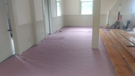 A room with a pink carpet and wooden floors.
