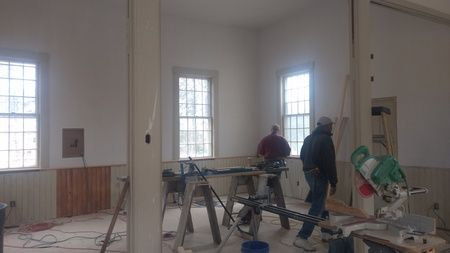A group of men are working on a building in a room.