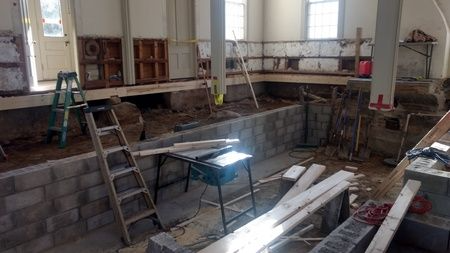 A room with a ladder and a table in it is being remodeled.