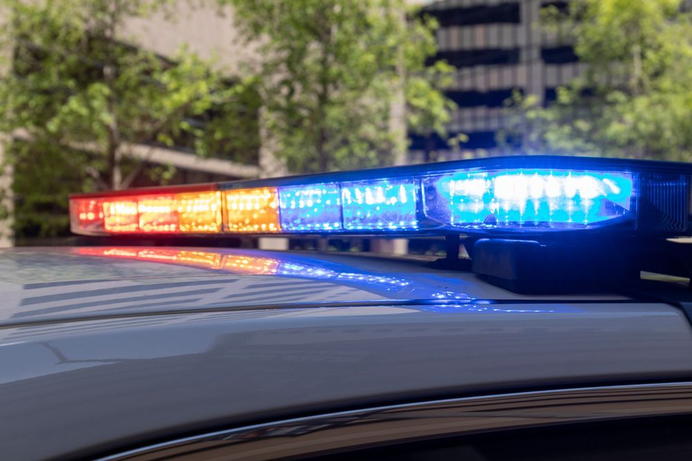 Police car light bar flashing red and blue on a vehicle roof outdoors