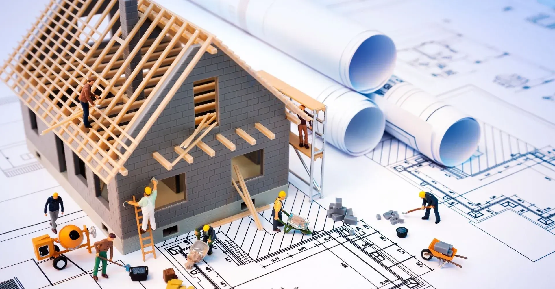 A model house is being built on top of a blueprint.