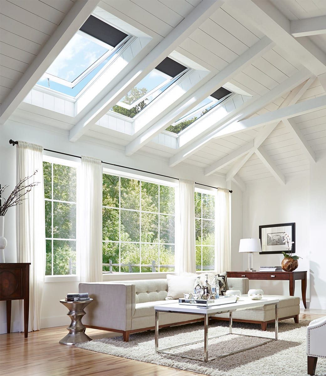 A living room with a vaulted ceiling and skylights
