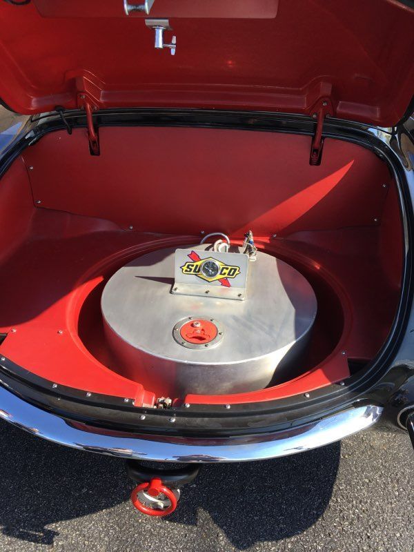 Rear compartment of a race car, with a large fuel tank, in red and silver.
