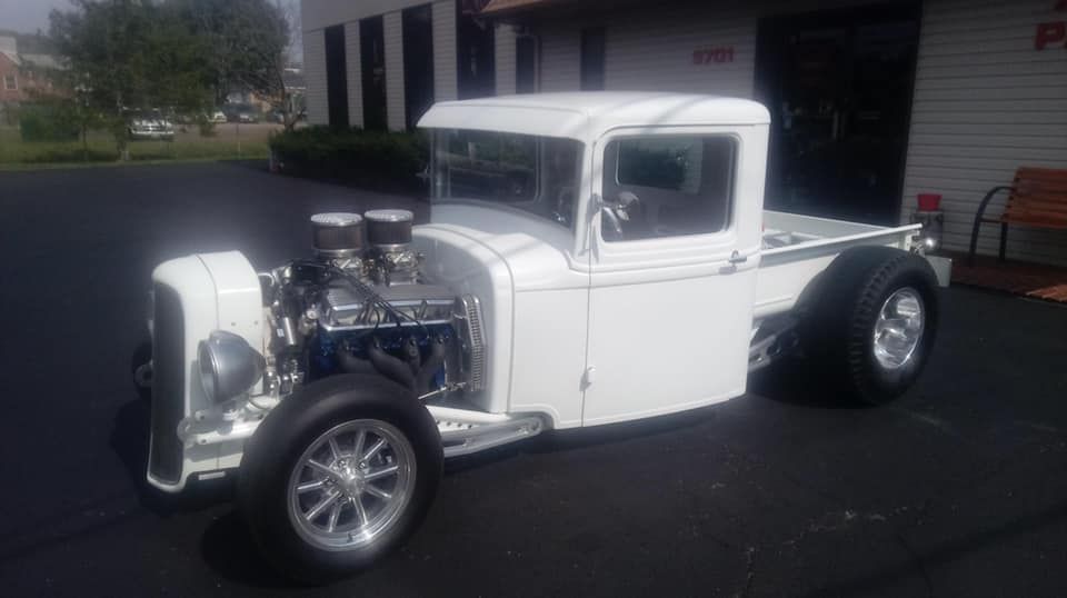 White classic hot rod pickup truck with exposed engine.