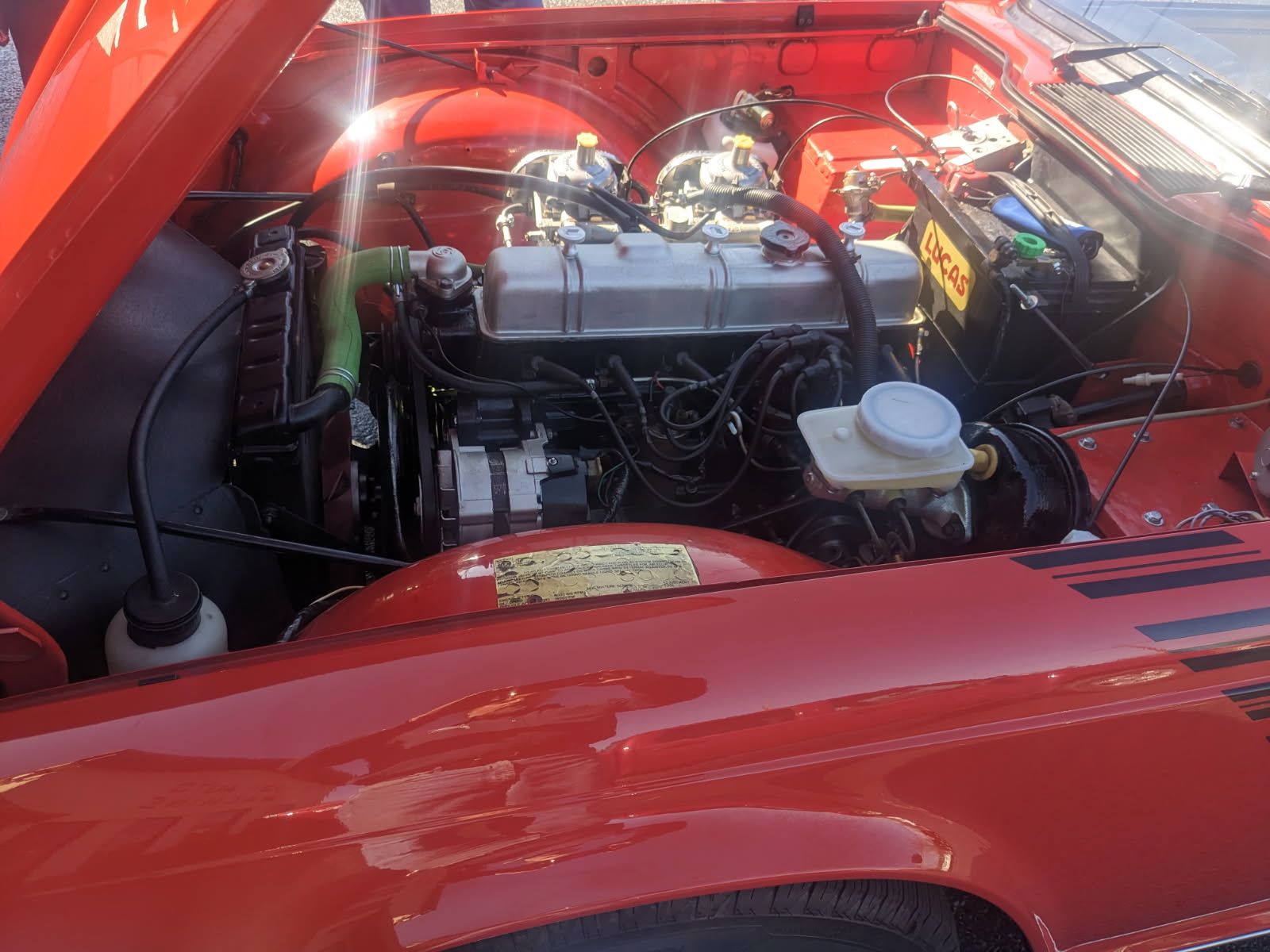 Red vintage car engine bay, showing engine and components.