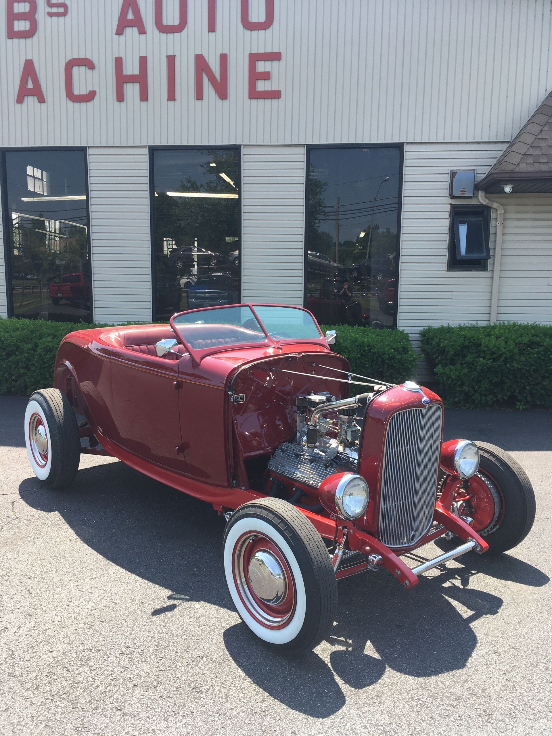 Red classic hot rod in front of 