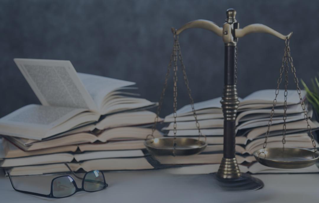 Scales of justice with books and glasses, representing law and knowledge.