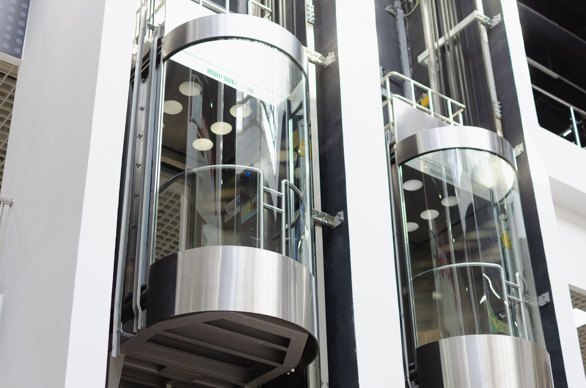 Glass elevators in a modern building lobby with chrome accents