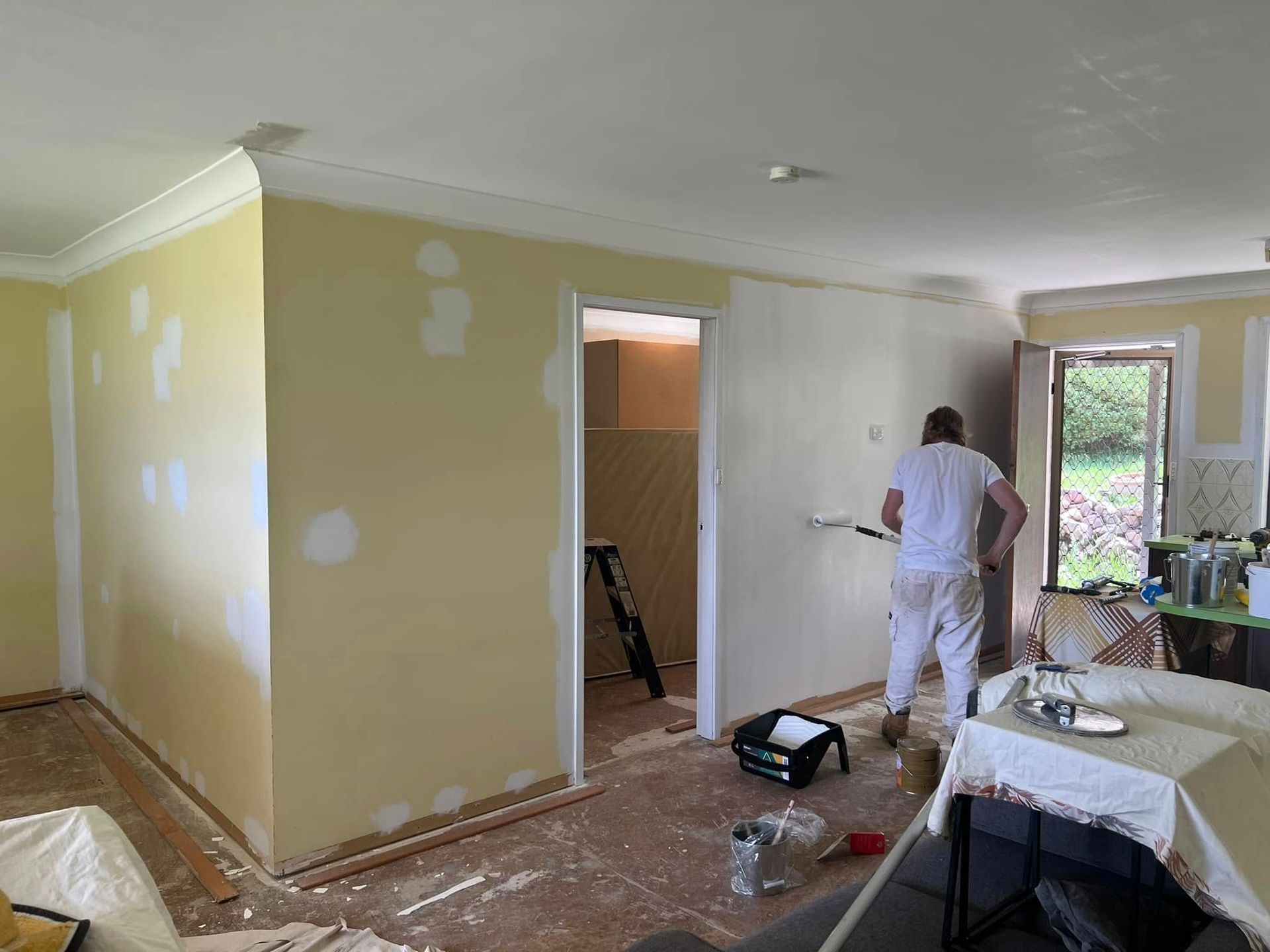 Person Painting a Yellow Room with White Patch Repairs — Matty Stewart Painting & Decorating in Orange, NSW
