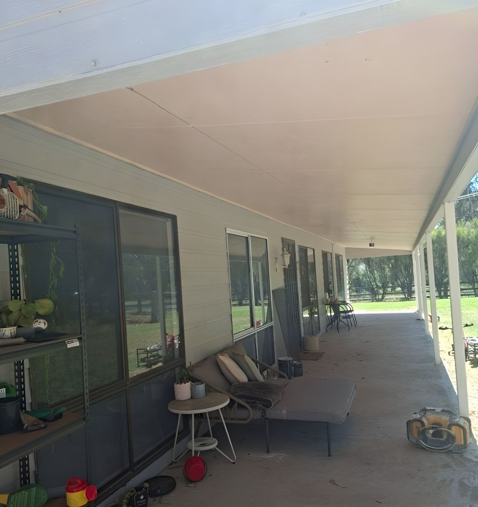 Covered Front Porch with Chairs and Toys Beside a House in Daylight — Matty Stewart Painting & Decorating in Mudgee, NSW