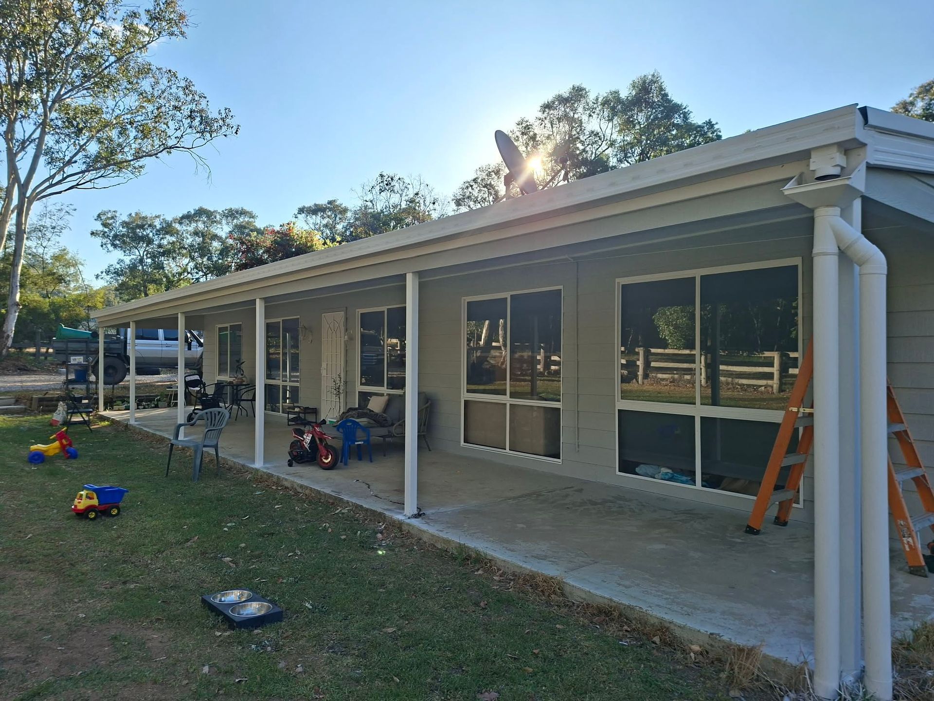 Single-story house with covered patio, large windows, and children's toys scattered on the lawn— Matty Stewart Painting & Decorating in Orange, NSW