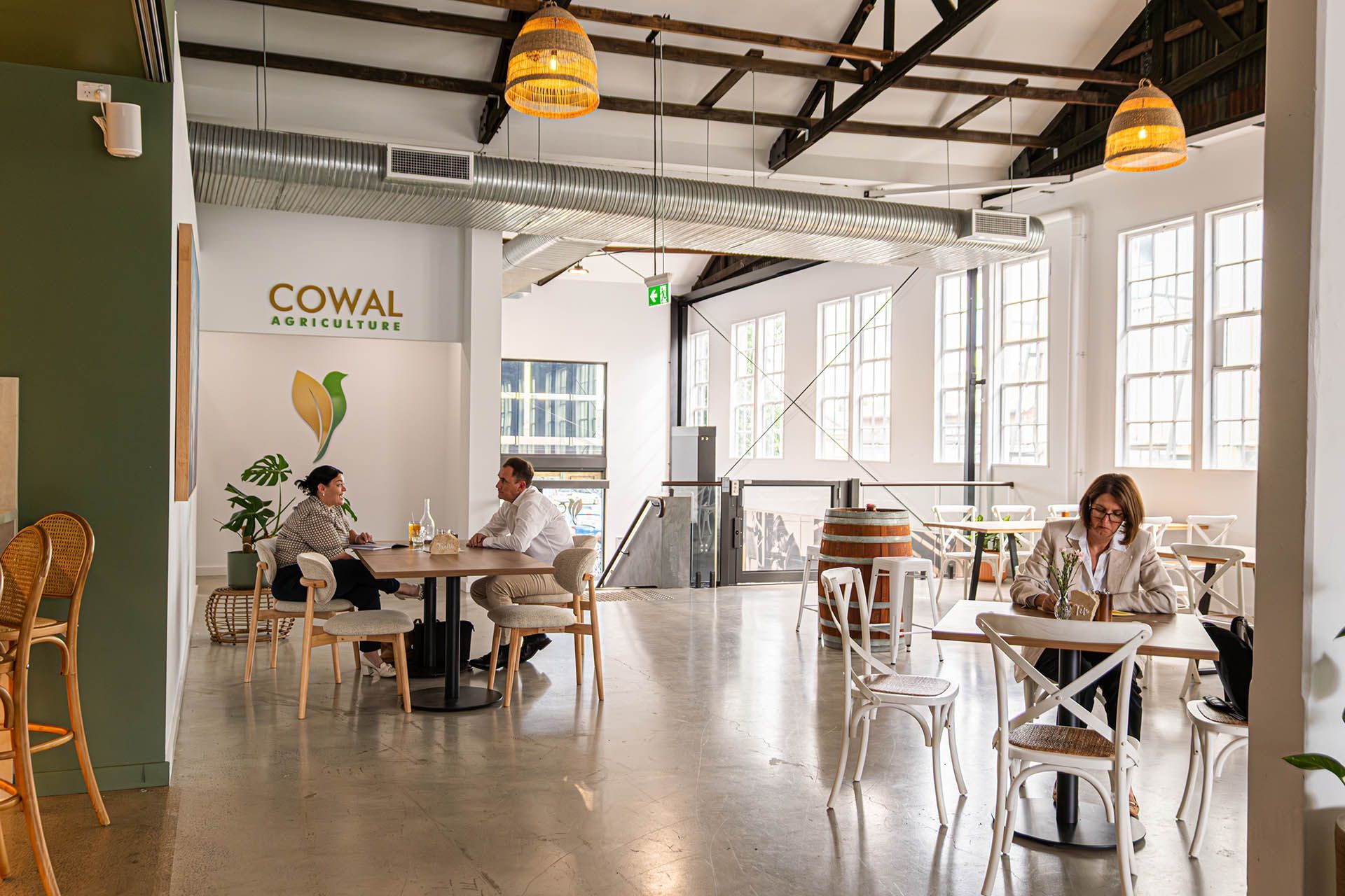 Bright café interior with people seated at tables and large windows letting in natural light