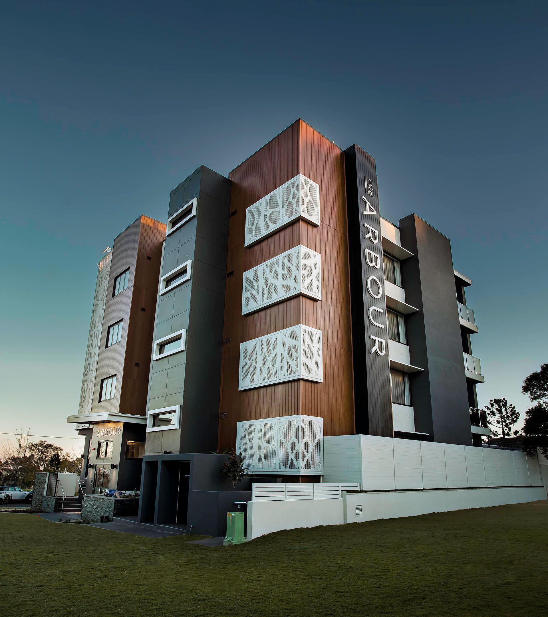 Modern multi-story building with wood and white facade accents against a clear sky