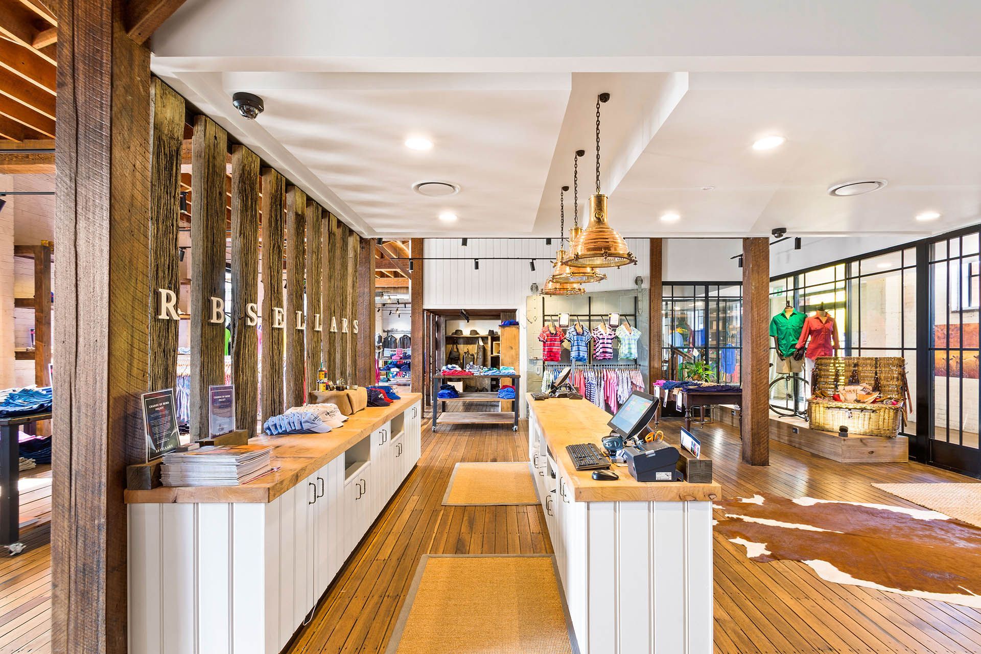 Bright retail store interior with white counters, wood floors, and colorful merchandise displays
