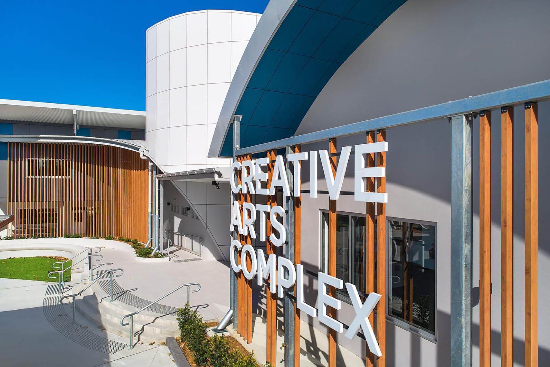 Creative Arts Complex building exterior with white sign and blue curved awning