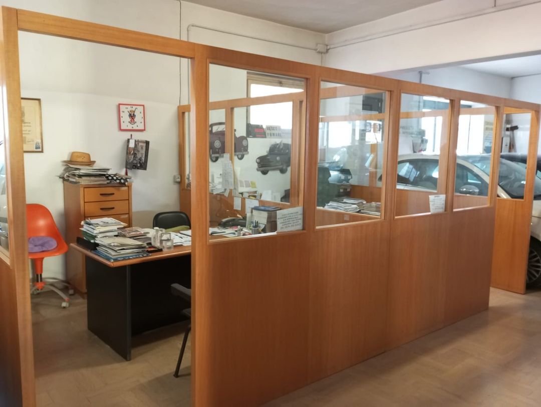 Una stanza con molte finestre e una scrivania