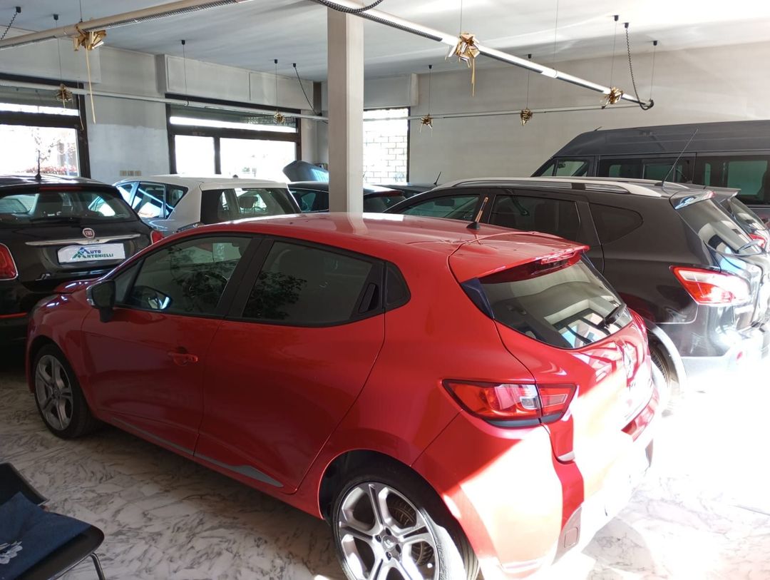 Un'auto rossa è parcheggiata in un garage con altre auto