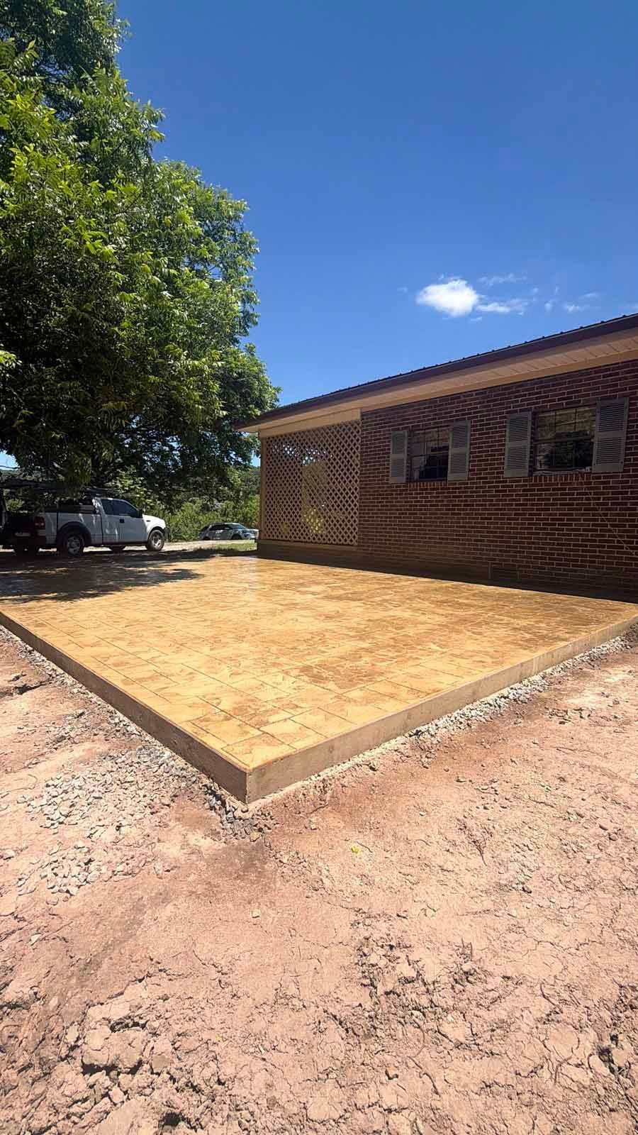 New wooden patio deck beside a brick house under a bright blue sky