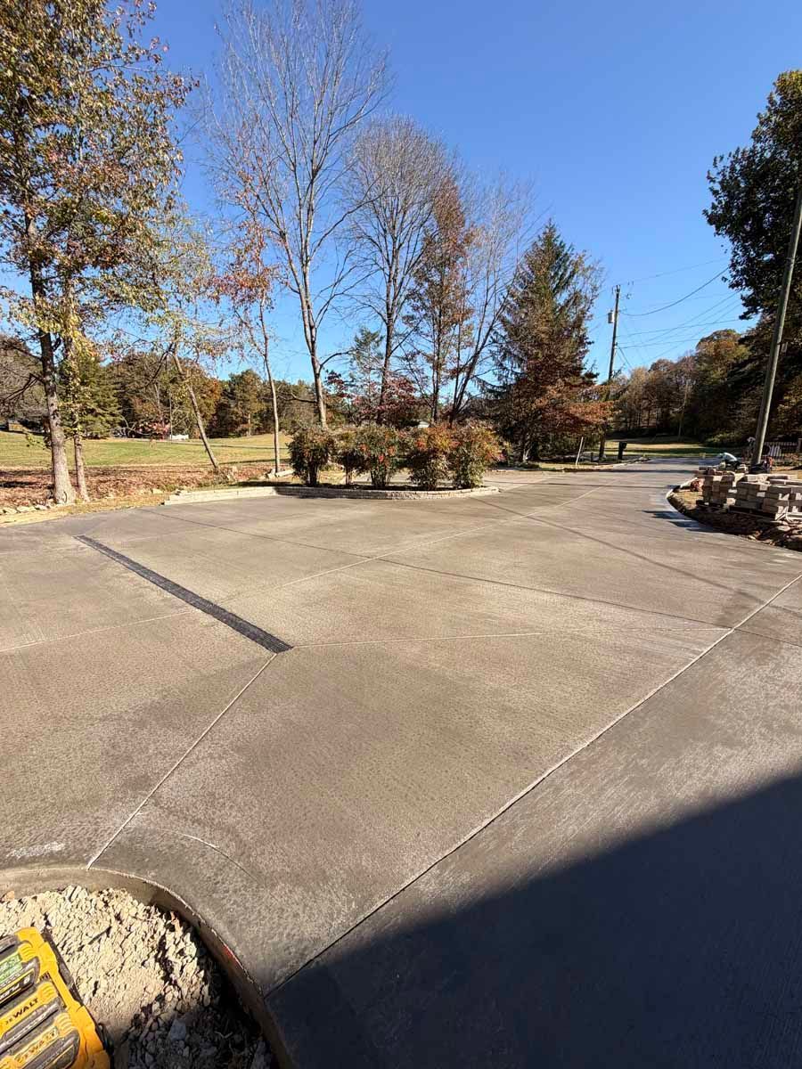 Empty concrete plaza with trees and shrubs under a clear blue sky