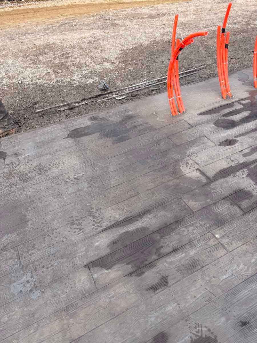 Gray rooftop with three orange safety vents or pipes near the edge