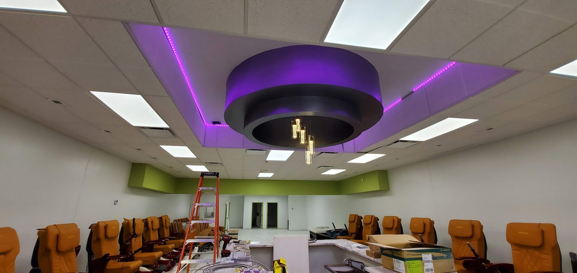 A large room with a purple light fixture hanging from the ceiling.