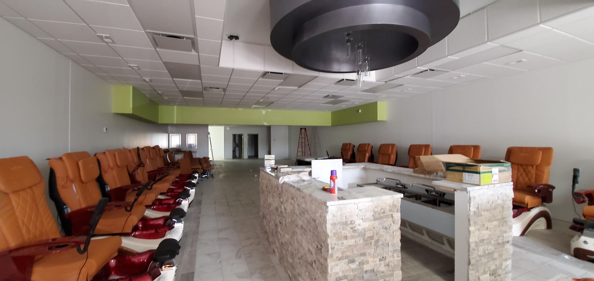 A nail salon with a lot of chairs and a counter.