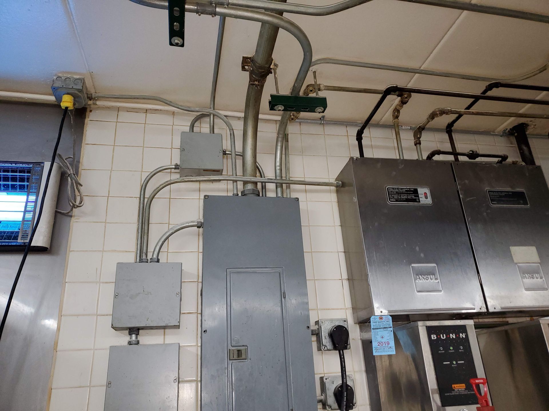 A kitchen with a lot of electrical equipment on the wall
