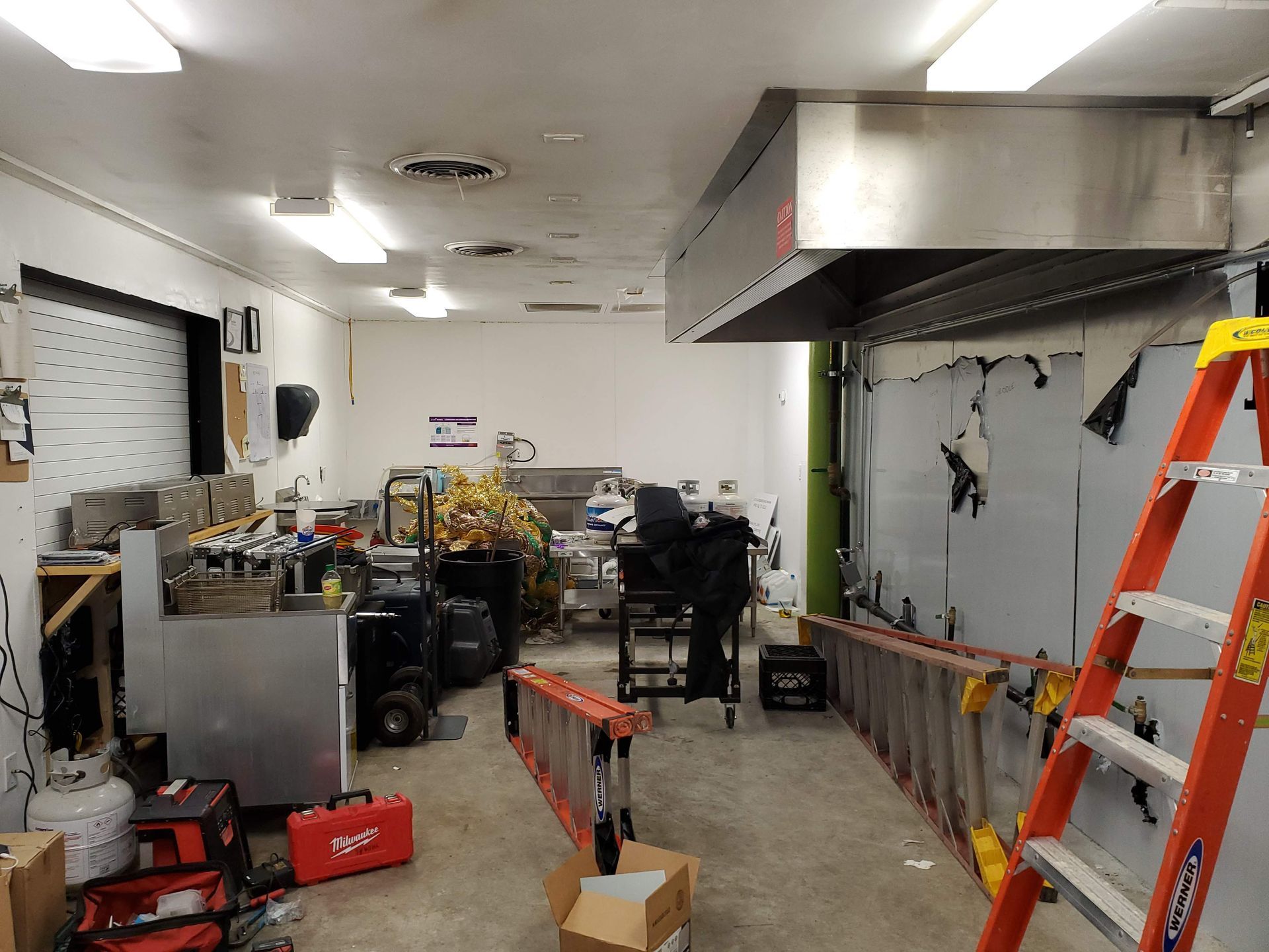 A kitchen with a lot of tools and ladders in it.