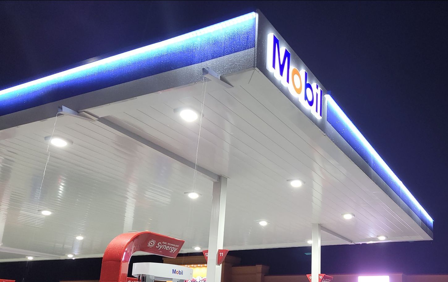 The roof of a mobil gas station is lit up at night