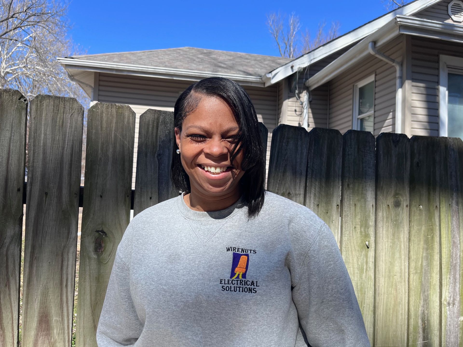 A LaTisha, Project Manager, in front of a white wall.