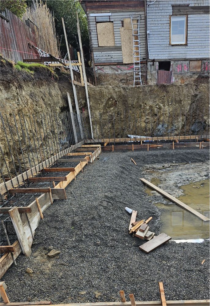 A construction site with a house in the background.