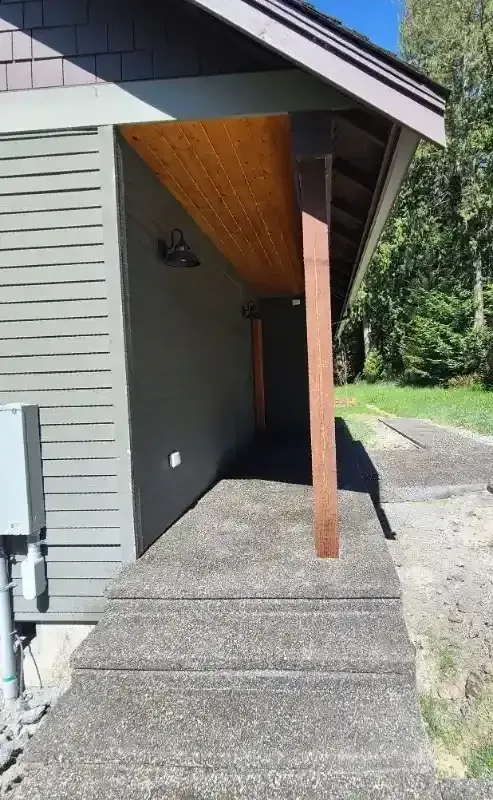 A house with a porch and stairs leading to it.