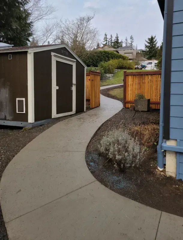 a concrete sidewalk leading to a shed and a house in Bellingham Washington.