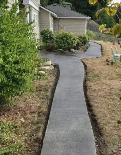 a concrete walkway leading to a house with a house in the background in Bellingham Washington.