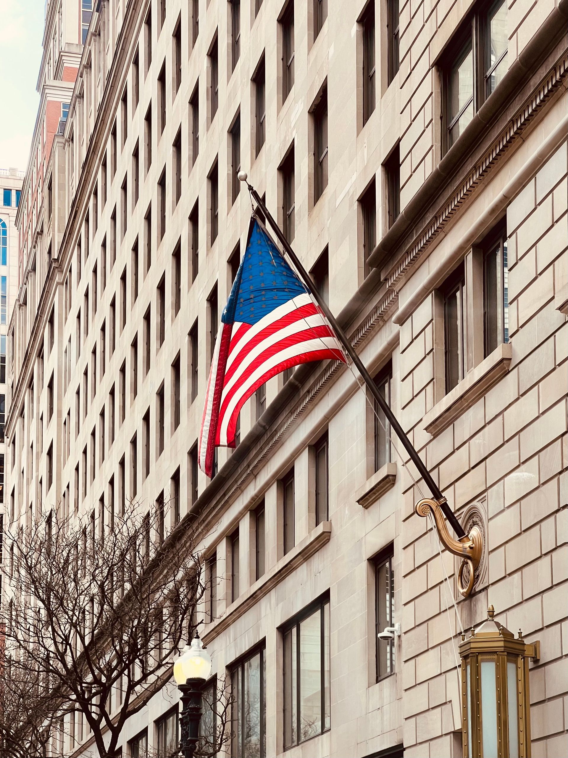 American flag on a building facade along a city street