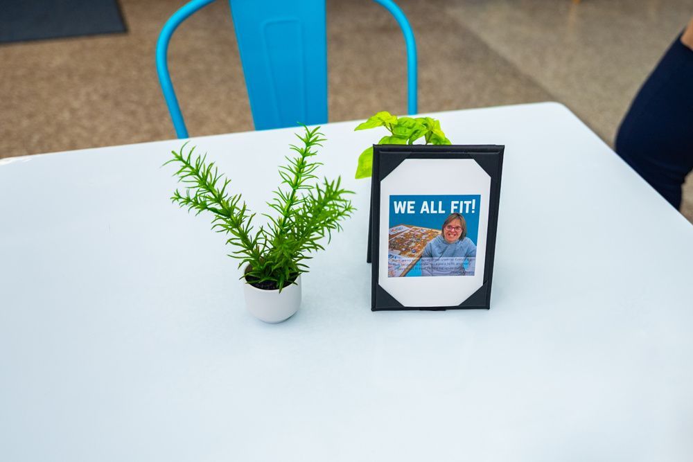 White table with potted plant and framed sign that reads 