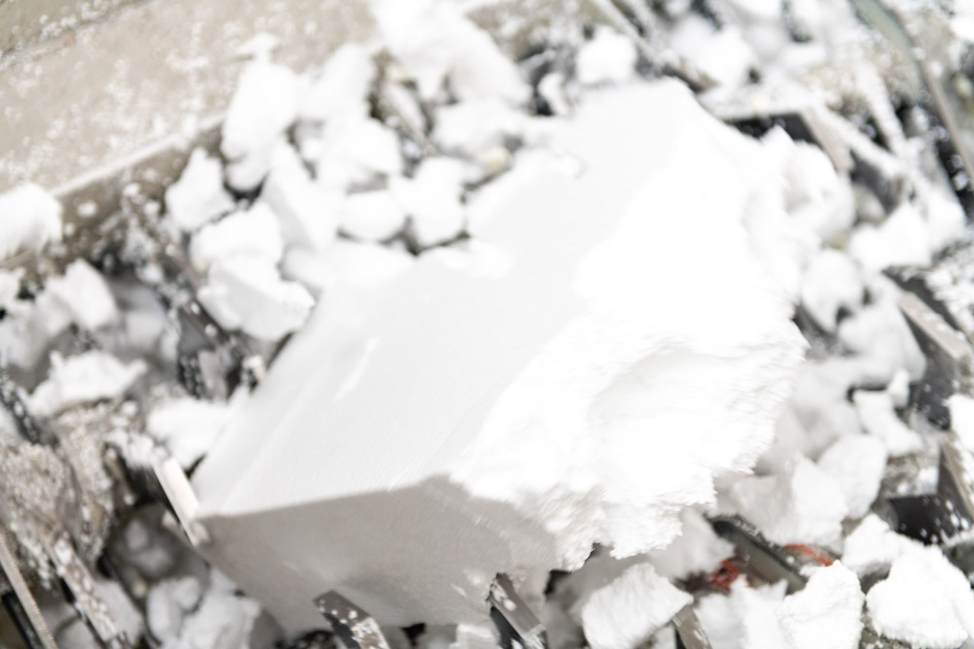Blocchi di ghiaccio bianco lavorati in una macchina.