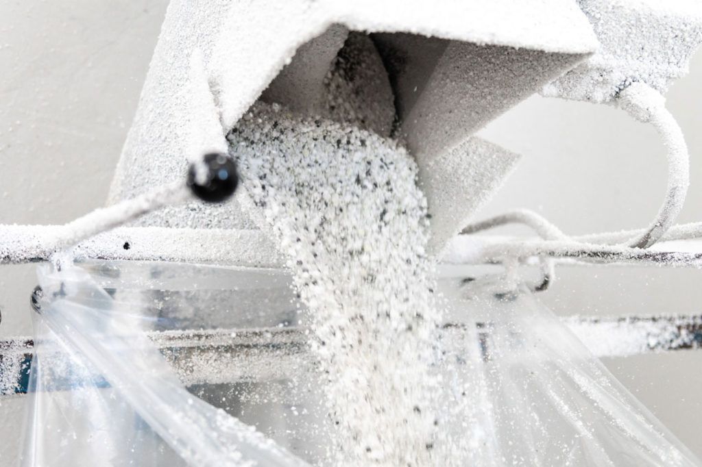 Polvere bianca che fuoriesce da una macchina e finisce in un sacchetto di plastica.