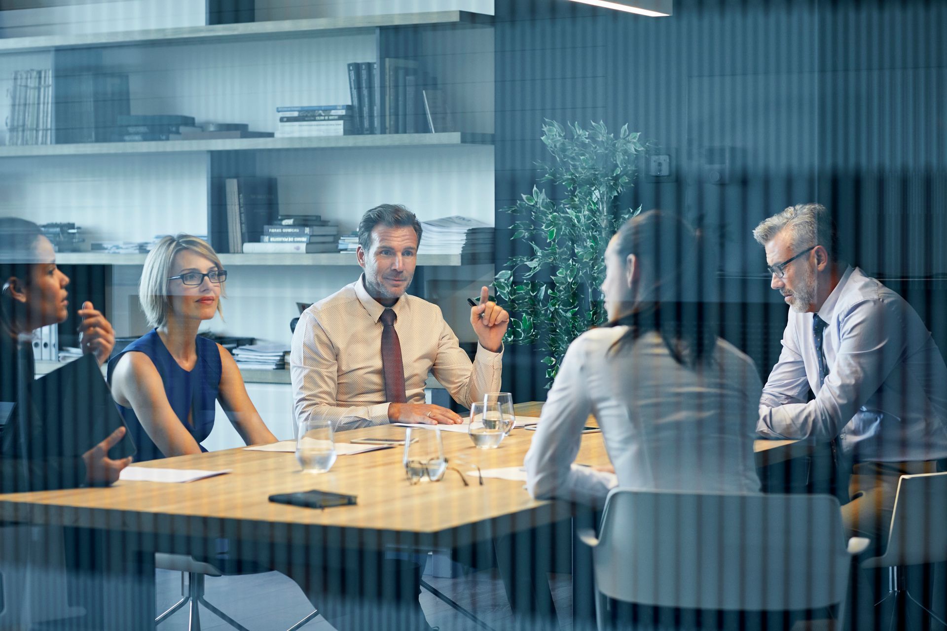 A group of people are sitting around a table having a meeting.