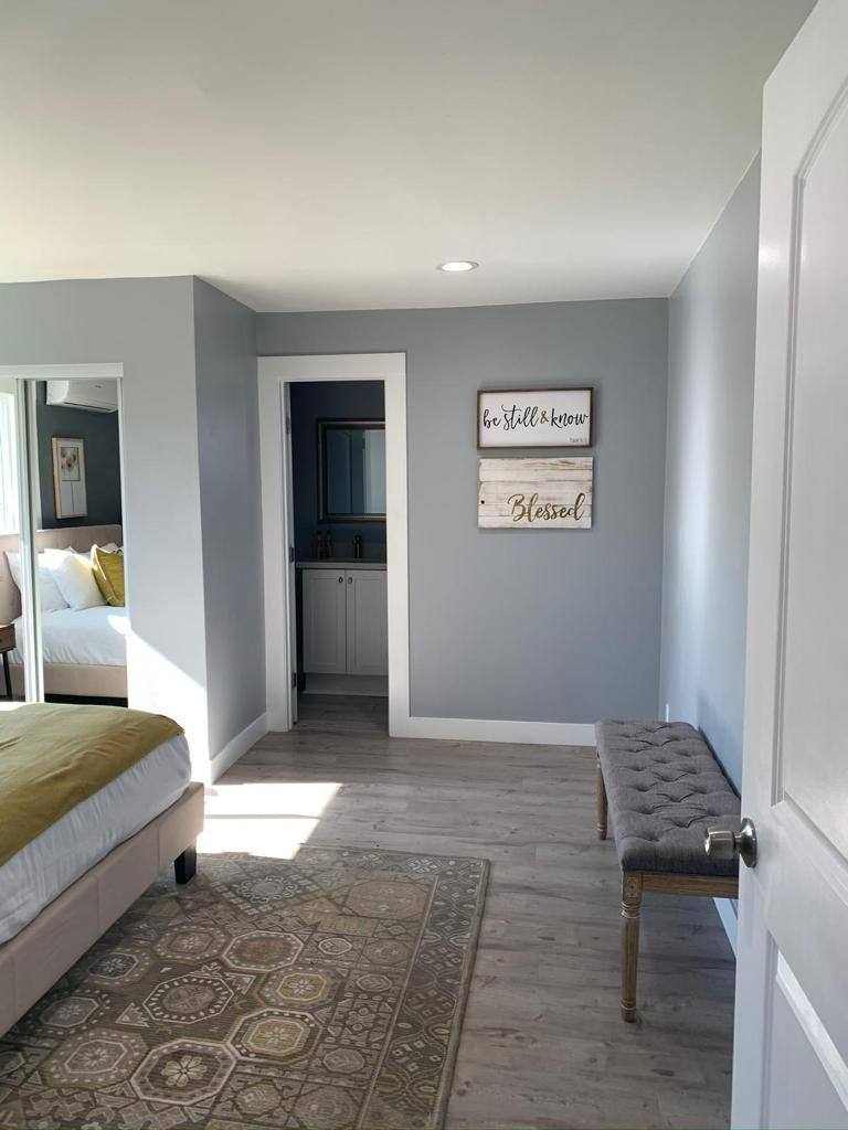 A bedroom with a bed , a bench , and a bathroom.
