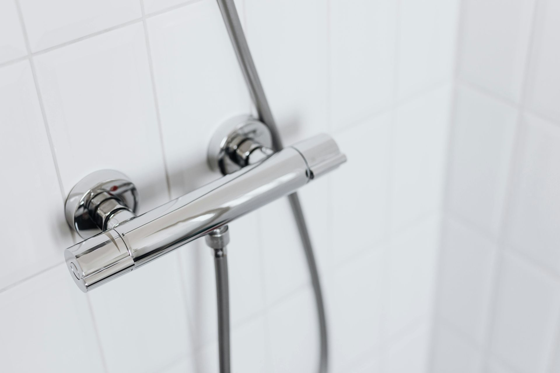 A close up of a shower head in a bathroom.