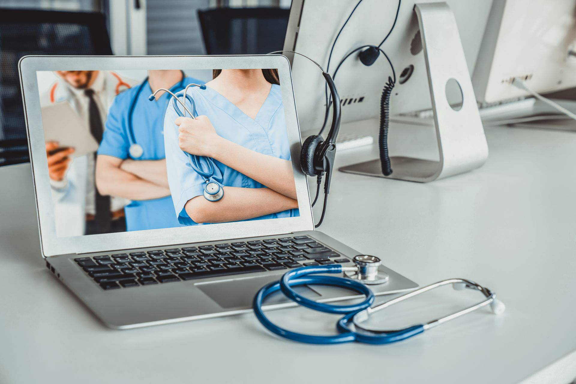 A laptop computer with a picture of a doctor and nurse on the screen.