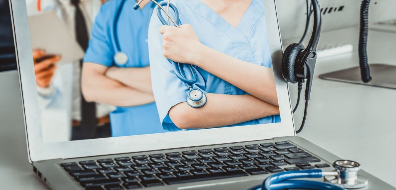 A laptop computer with a picture of a doctor and nurse on the screen.