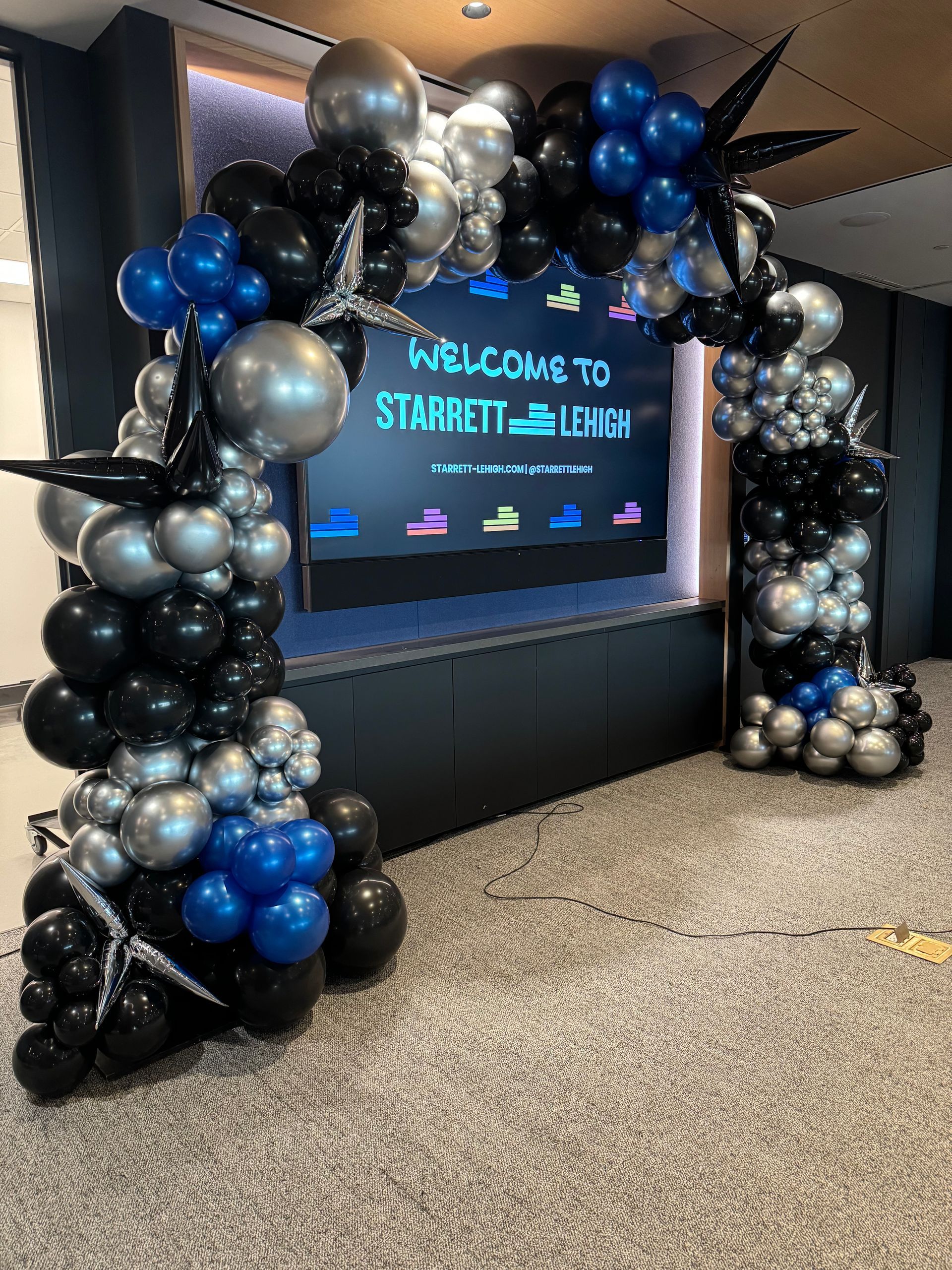 A room filled with balloons and a welcome sign.