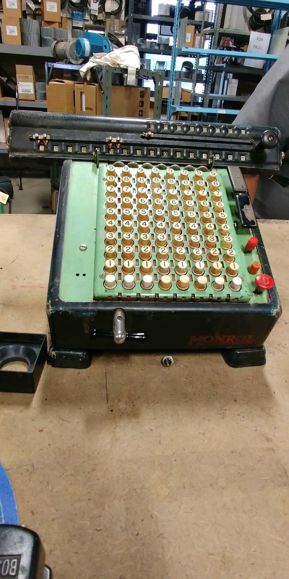A green and black calculator is sitting on a wooden table.