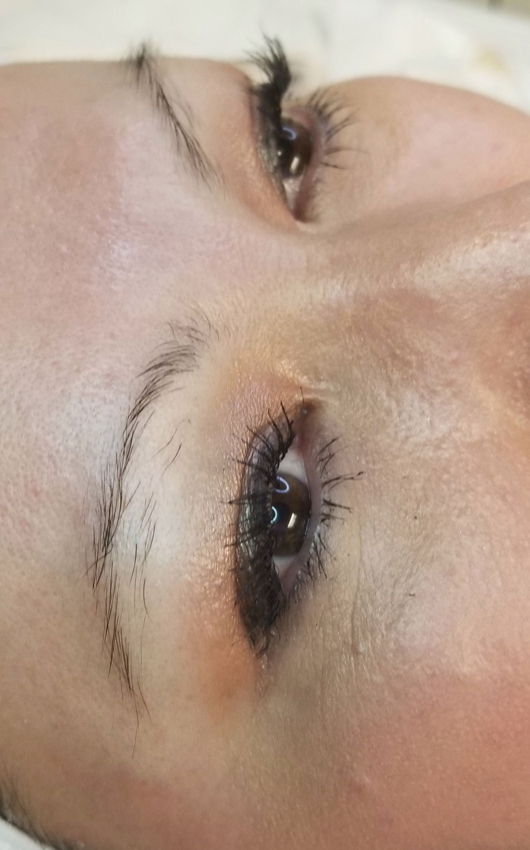 A close up of a woman 's face with long eyelashes.