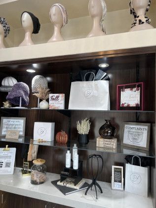 Display of head coverings and skincare products in a boutique, with shopping bags and decorative items.