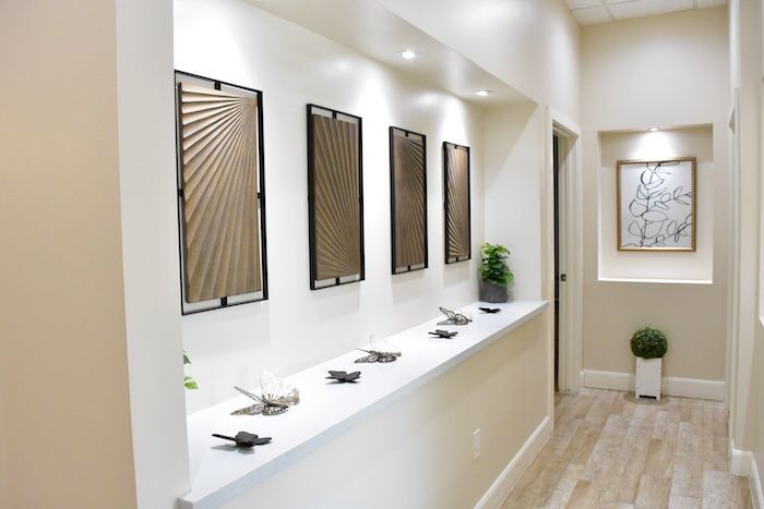 Hallway with art, recessed lighting, and decorative items.
