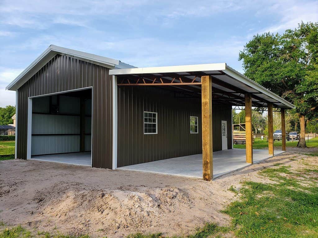 A large metal building with a porch and a garage door.
